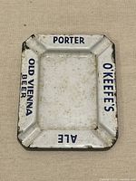 Front view showing text O'KEEFE'S, ALE, PORTER, OLD VIENNA BEER and enamel wear