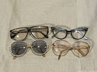 Four pairs of eyeglasses laid out showing front view and styles