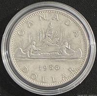 Voyageur reverse of 1966 Canadian silver dollar showing canoe design and date