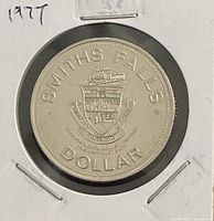 Obverse of 1977 Smiths Falls trade dollar in 2x2 holder