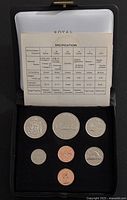 Open presentation case showing seven coins and specification card