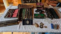 Overview showing flutes in cases, binoculars, compasses, cruets, domino set, portrait miniature, minaudière