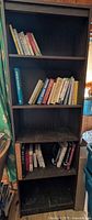 Full front view of bookshelf with books on upper shelves