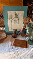 Group shot showing artwork, cat figures, green glass vase, wicker items