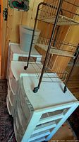 Two plastic drawer towers, wire rack on top, planter pot visible