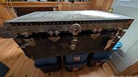 Closed vintage trunk showing metal bindings and overall wear