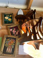 Group shot of three framed floral embroideries and wooden shelf components