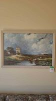 Full view of framed landscape art print in light wood frame