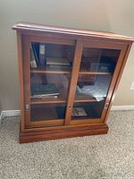 Full view of glass-front wooden bookcase with sliding doors and interior shelves
