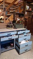 Overall view of workbench area with rotating tool caddy, green toolbox and drawer cabinets