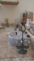 overview of cruet set in metal caddy, aluminum cake cover, surrounding items