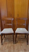 Two wooden chairs side by side showing overall design and finish