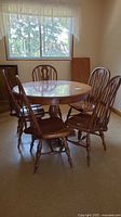 Table with four Windsor chairs around, hardwood finish visible