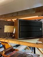 Sony SS-310 speaker on wooden shelf showing cabinet, grille, attached wire