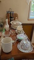 overall lot on countertop showing pepper mill, spice rack with jars, porcelain covered dish, glassware