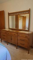 Front view showing dresser, mirror, drawers, cabinet doors, marble-look inserts