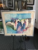 Full view of framed serigraph on easel showing artwork, mat and frame