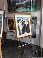 Framed painting on brass easel in storefront