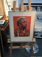 Framed serigraph on easel showing full item