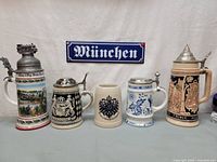 Group shot of five German beer steins and München sign