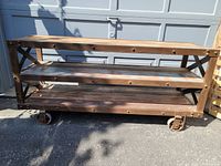 Full view of three-shelf industrial console table on caster wheels