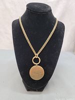 Front view showing chain and engraved pendant side