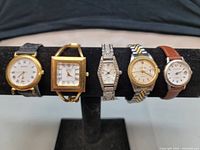Front view of all five wristwatches on display stand