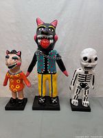 Front view of all three painted papier-mâché figures