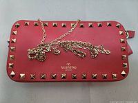 Front view of red Valentino Garavani Rockstud bag with chain