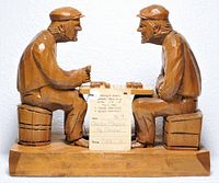 Front view of wooden sculpture showing both figures and table