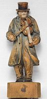 Front view of wooden violin player sculpture showing full figure and base