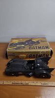 Batmobile toy car placed in front of original box
