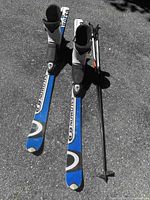 Full view of skis, boots and poles on ground