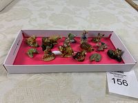 Overall view of 15 figurines in tray