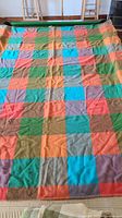 Full view of Invicta multicolour blanket laid out, partial view of Godfrey Hirst blanket at foot