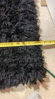 close-up of rug edge with measuring tape showing width