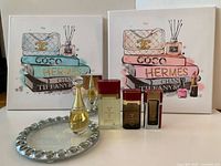 Full lot view showing two canvas prints, six perfume bottles and beaded glass tray
