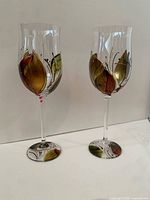 two wine glasses showing painted leaf motif on bowls and bases