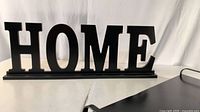 Black “HOME” sign on base