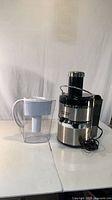Juicer base beside water filter jug