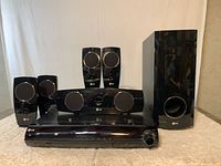 Full set showing DVD receiver, subwoofer, center speaker and four satellite speakers