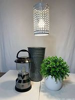 All four items group view: lantern, galvanized vase, swag light illuminated, artificial plant