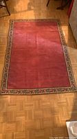 Full view of burgundy rug with floral border