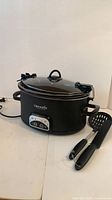 Slow cooker with utensils shown
