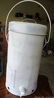 Full view of white metal milk can with lid and wire bail handle