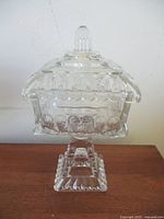 Front view of clear pressed glass covered pedestal compote on base
