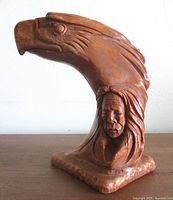 Full view of carved stone sculpture on wooden surface