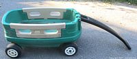 Side view of green and beige Little Tikes wagon with black handle