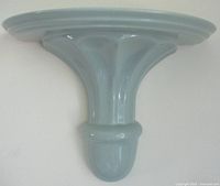 Front view of glossy aqua ceramic wall shelf showing overall design