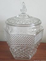 Front view of clear pressed glass Wexford jar with lid